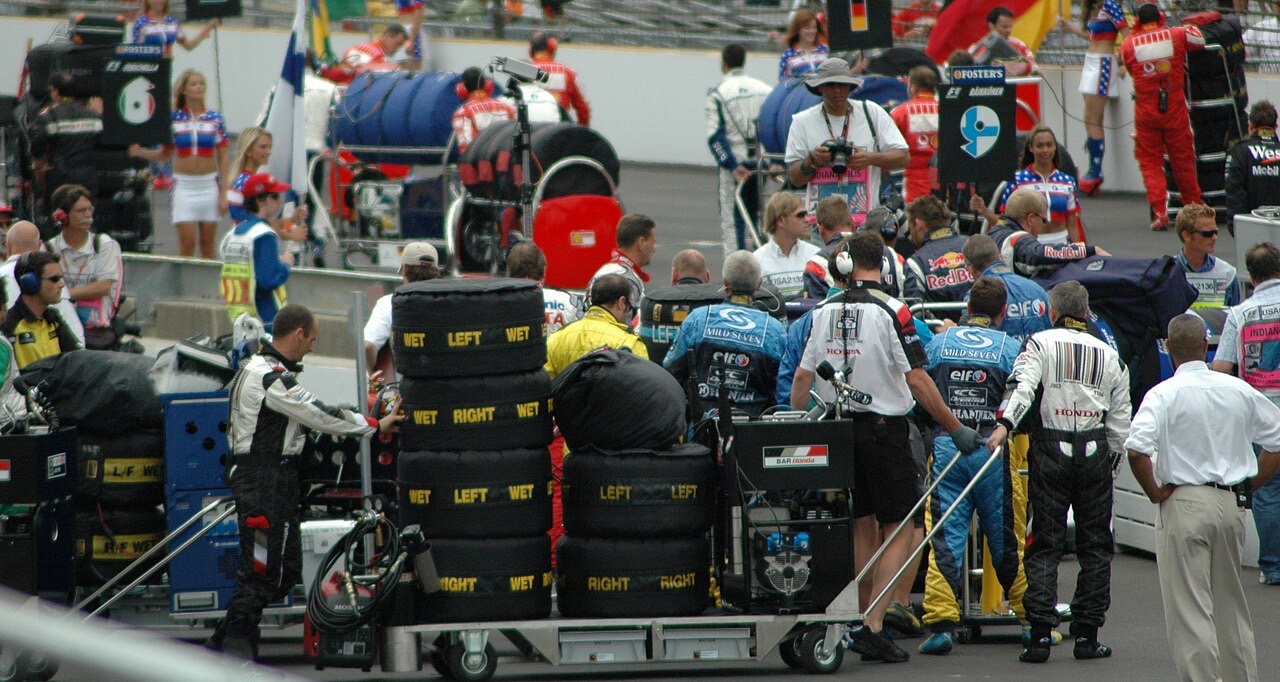 Crews pushing carts stacked with tyres onto the grid at the 2005 United States Grand Prix